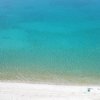 Spiaggia con mare azzurro visto dall'alto.