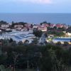 Complesso alberghiero vicino al mare circondato da case e natura.