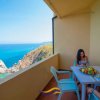 Balcone con vista mare, tavolo e due persone.