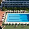 Piscina rettangolare circondata da lettini e ombrelloni.