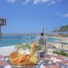 Tavolo con piatti, calici e vista sulla spiaggia.