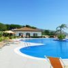 Piscina circondata da sdraio e ombrelloni, vista mare e cielo azzurro.